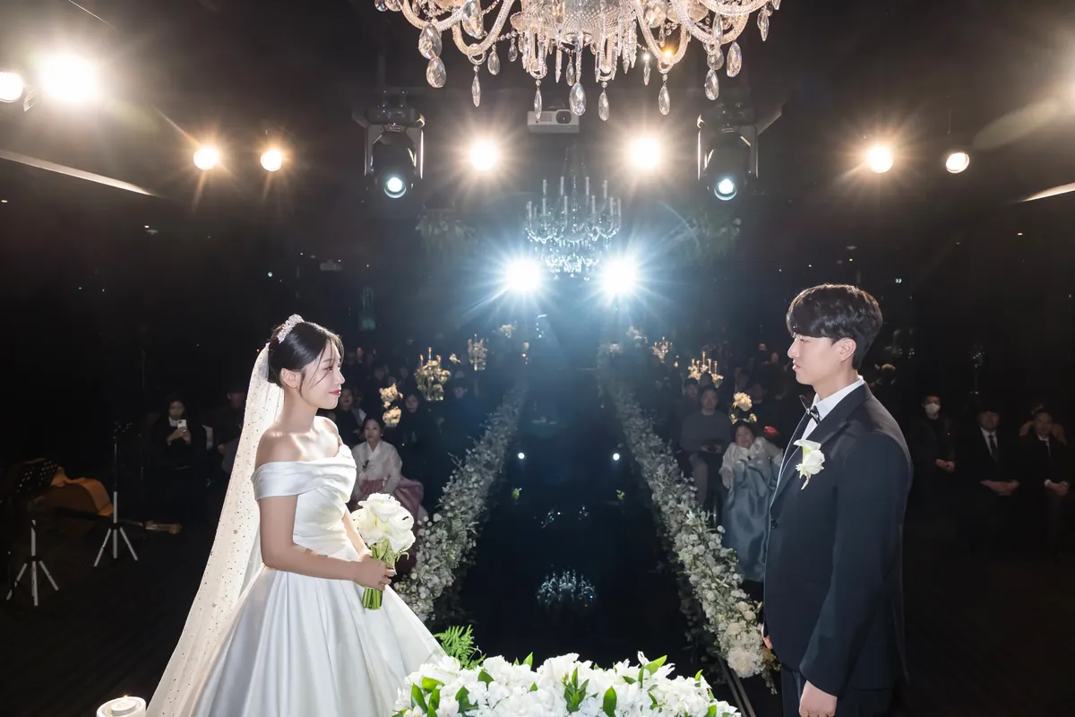 서울 강남구 세인트메리엘 본식dvd 업체 촬영 사례 — 핀 조명 아래 버진로드에서 마주 선 신랑신부 (2025.01)